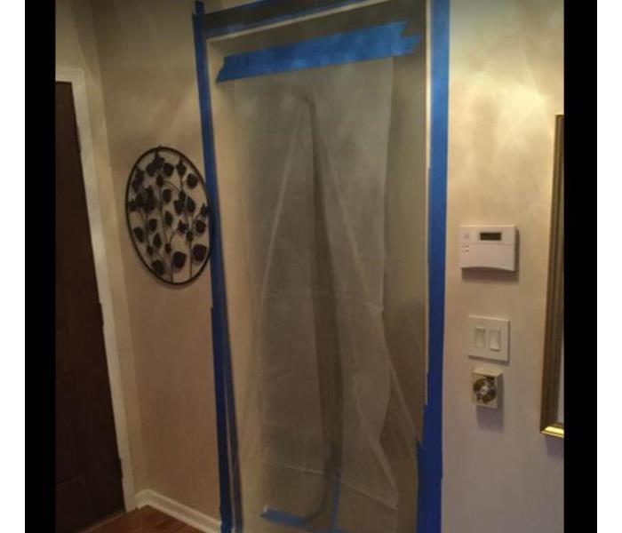 plastic containment sheeting over doorway in residential home