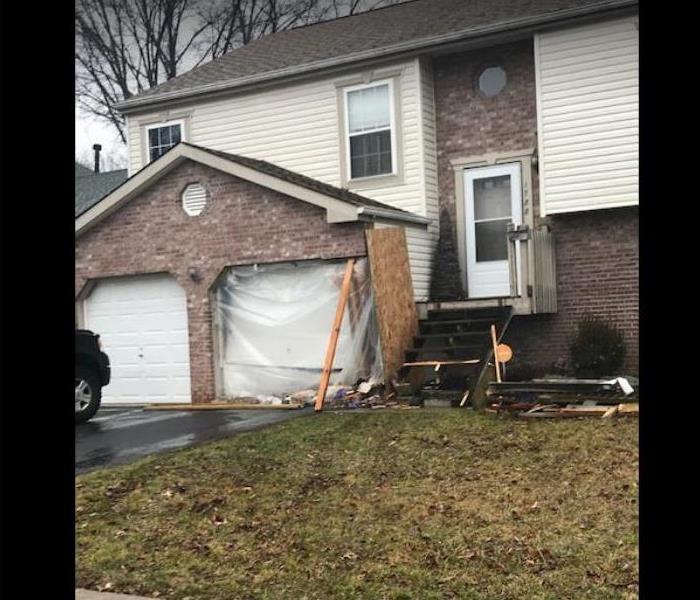 garage and side of home damaged by car