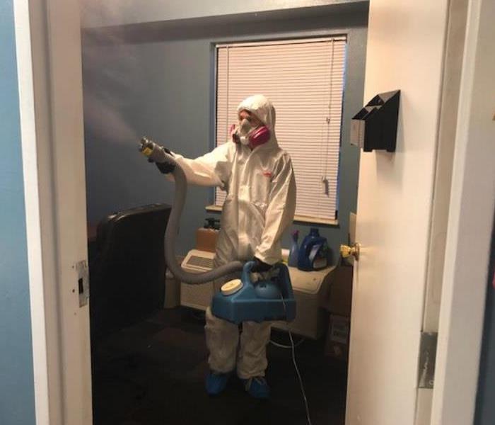 technician in ppe doing covid clean